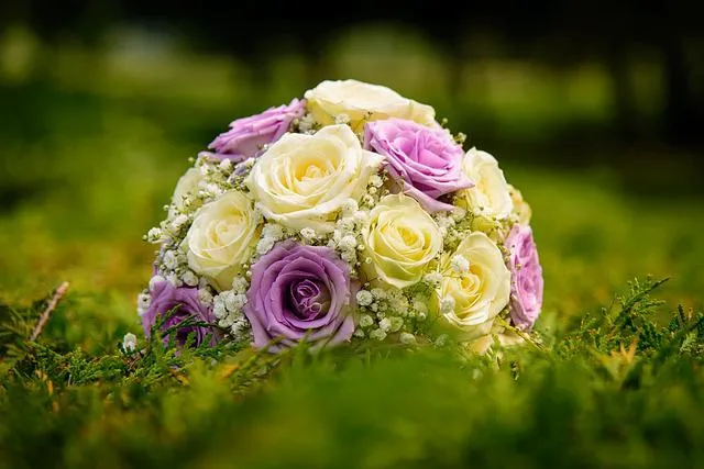SC Corina Spriestersbach - Freie Rednerin - Bouquet aus weißen und lavendelfarbenen Rosen mit kleinen weißen Füllblüten auf grünem Gras.